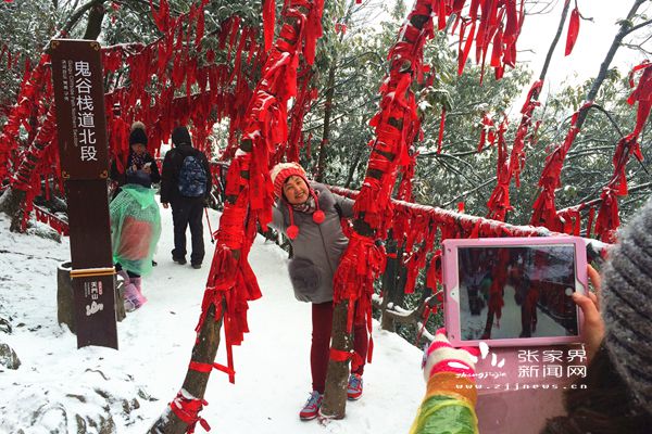 鬼谷栈道上挂满祈愿带的“红树林”在白雪中分外妖娆，吸引游人拍照 丁云娟摄_副本.jpg