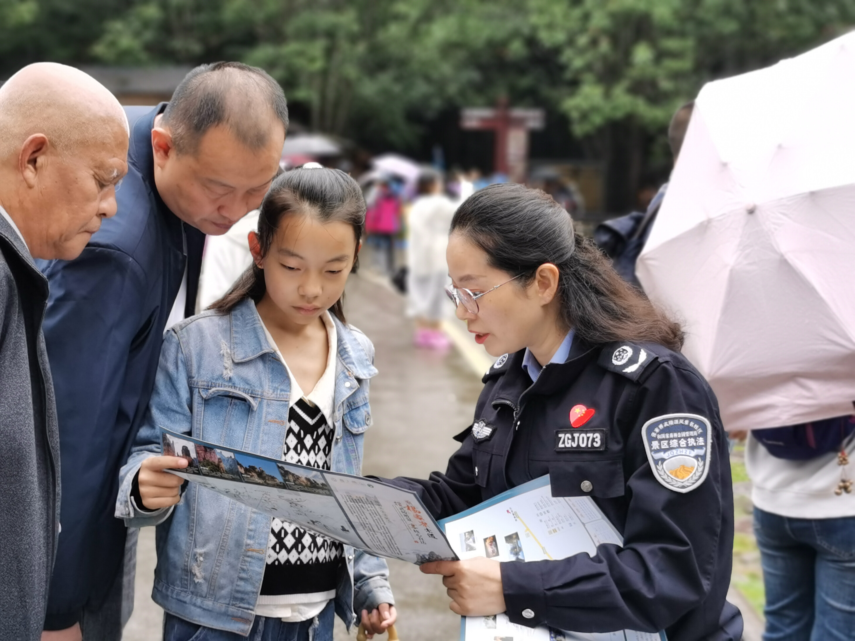 10月1日上年，金鞭溪景区管委会女子执法队队员开展流动导览服务，为游客免费赠送地图。张娜 摄